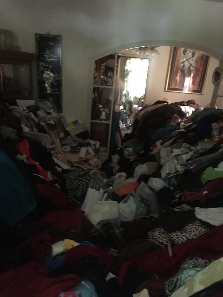 Interior of a hoarder's home with large piles of clothes