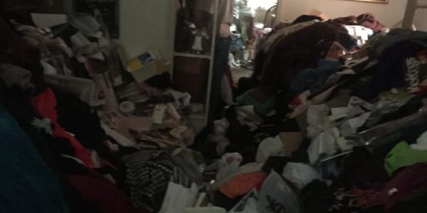 Interior of a hoarder's home with large piles of clothes