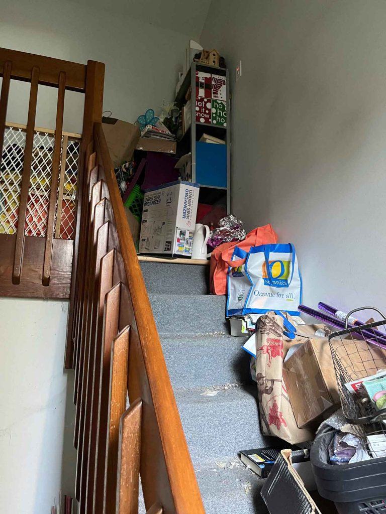 Stairs in house cluttered with junk
